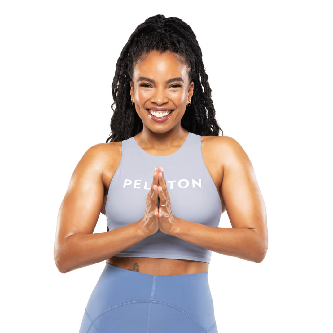Chelsea Jackson Roberts wearing a Peloton shirt with her hands in prayer pose