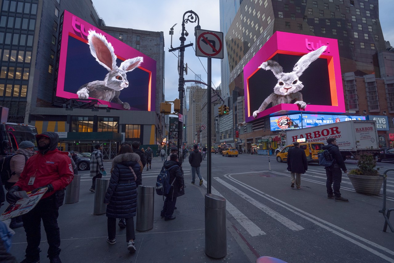 Two digital screens on opposite sides of a street, showing a Tubi ad