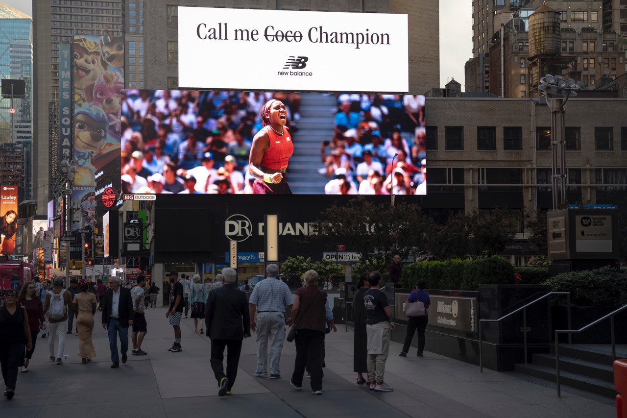 Two digital screens on top of each other, sitting on top of a Duane Reade. They contain two parts of a New Balance ad featuring Coco Gauff.