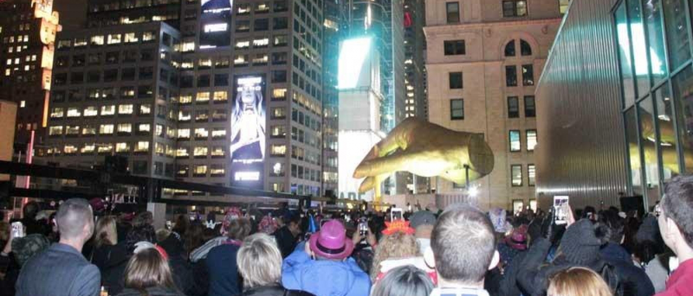A crowd watches the Ball drop on the terrace of the AMC 42