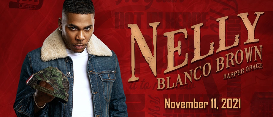 Nelly wearing a denim jacket and holding a camo trucker hat with text reading "Nelly, Blanco Brown, Harper Grace, November 11 2021, Palladium Times Square"
