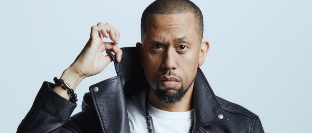 Affion Crockett holding up the collar of his leather jacket
