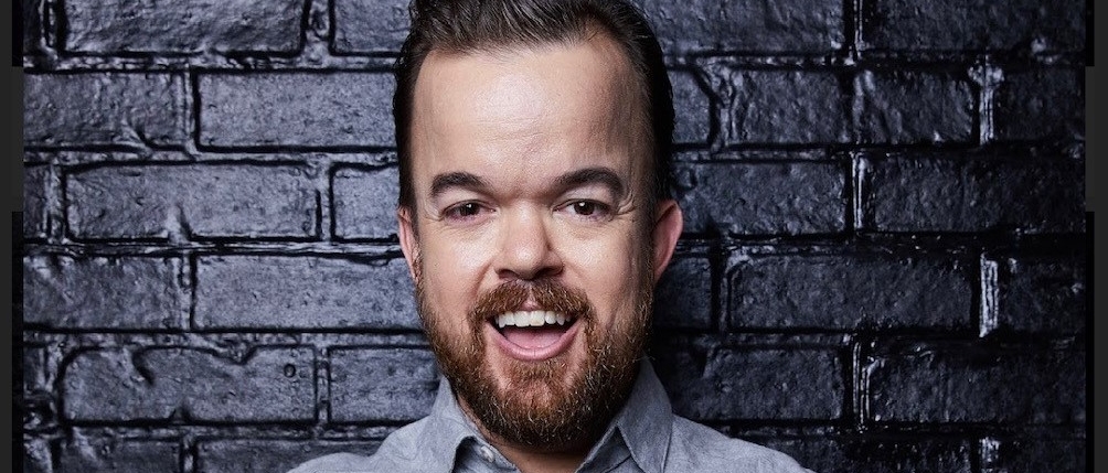 Brad Williams in front of a black brick wall