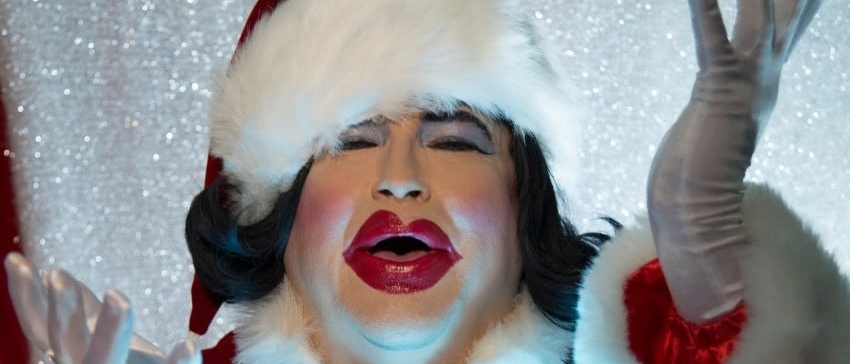 Dina Martina in a Santa outfit and her characteristic overdone asymmetrical makeup