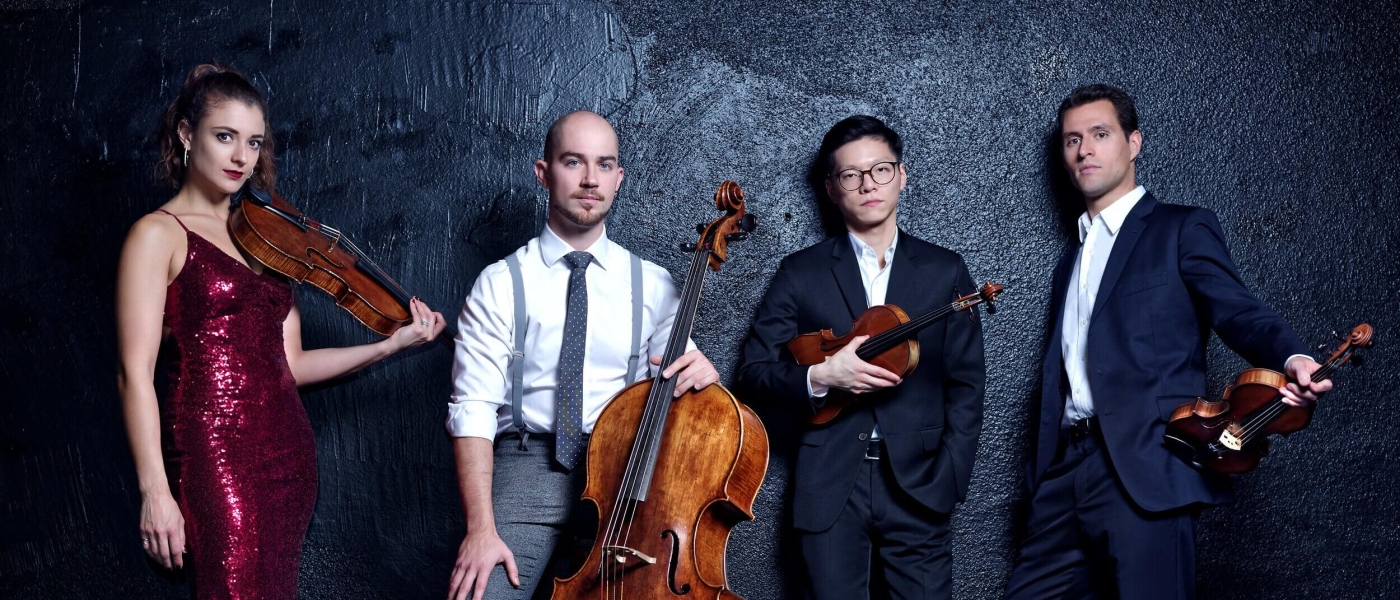 Dover Quartet in formal attire carrying string instruments
