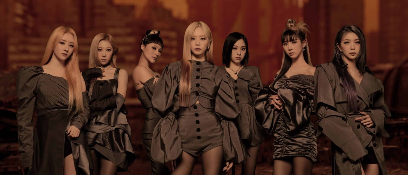 Dreamcatcher in grey outfits in front of a backdrop of a destroyed city