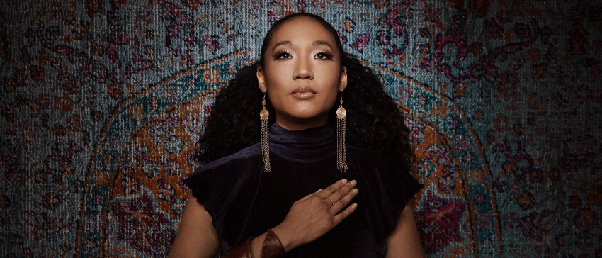 Judith Hill standing in front of a woven patterned backdrop