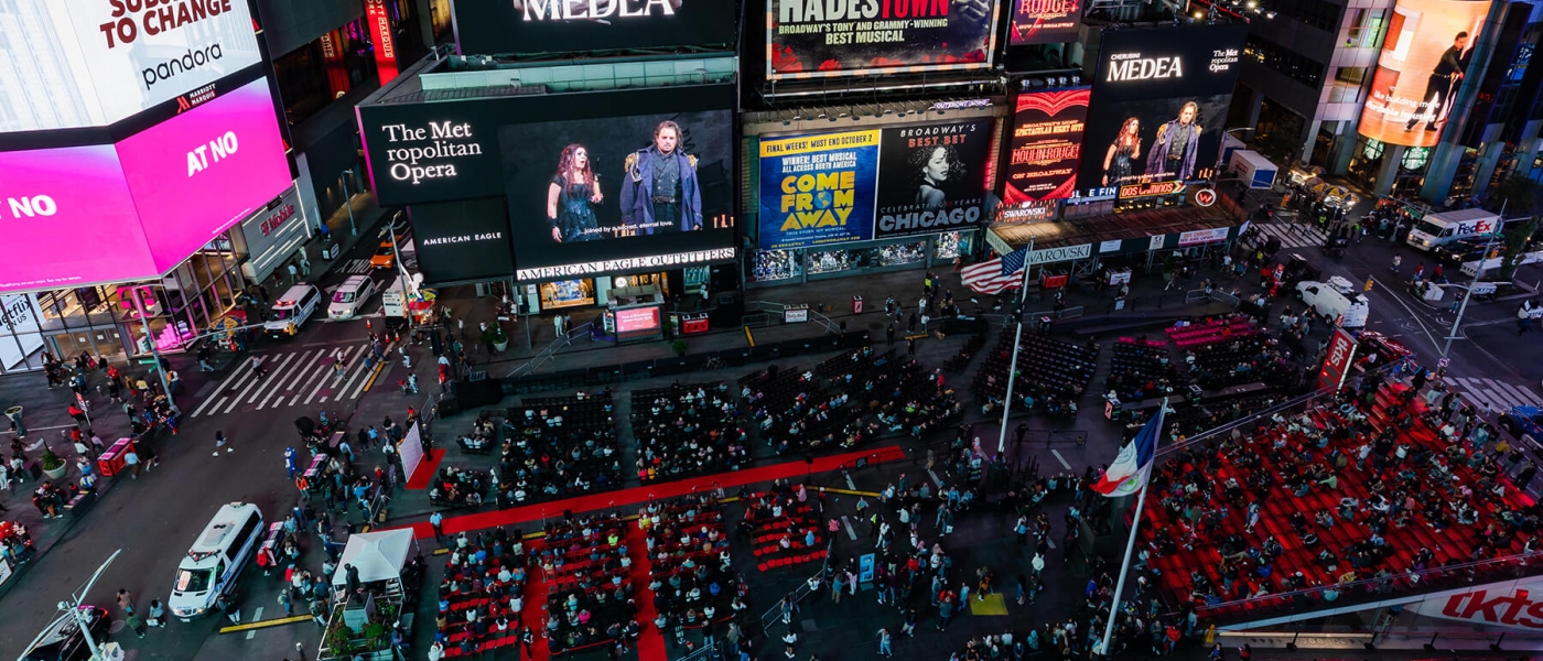 Aerial photo of the 2022 Met Opera Opening Night simulcast of Medea in Times Square, with a red carpet and seats spread out over a Broadway plaza