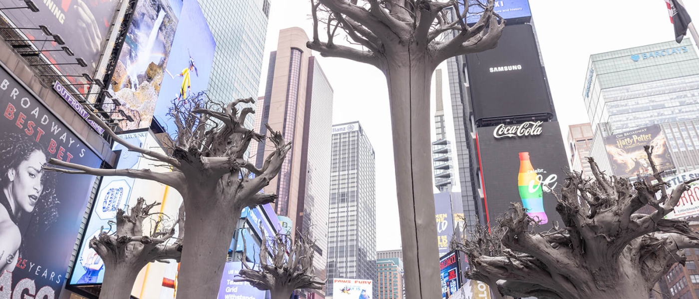 The sculptural installation Roots in Times Square, featuring gray-painted upside-down trees