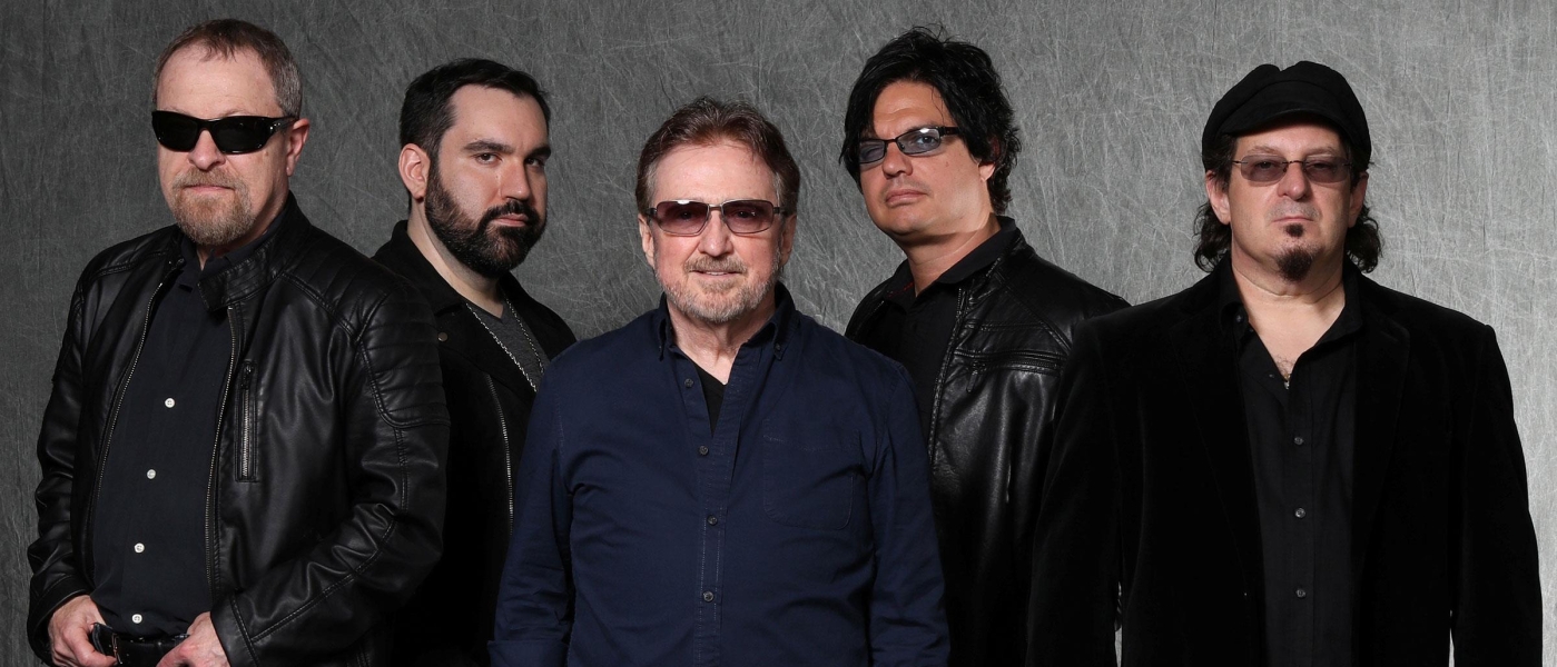 Blue Öyster Cult in front of a grey background