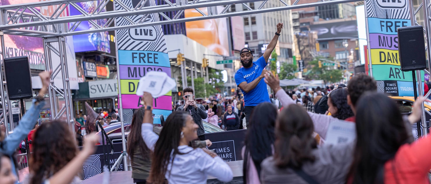An Ailey Extension instructor leading an outdoor workshop in Times Square as part of TSQ LIVE