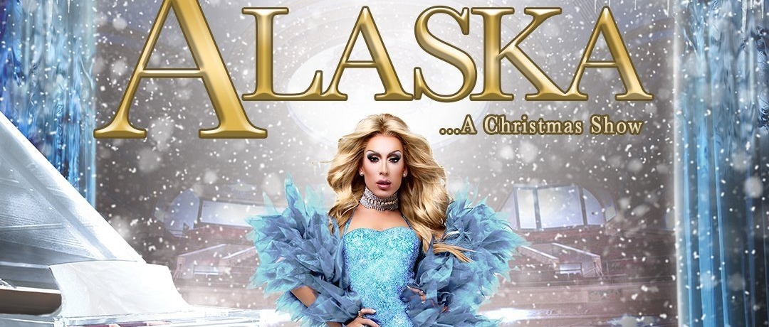An image of drag queen Alaska in a dramatic blue dress with a snow effect around her