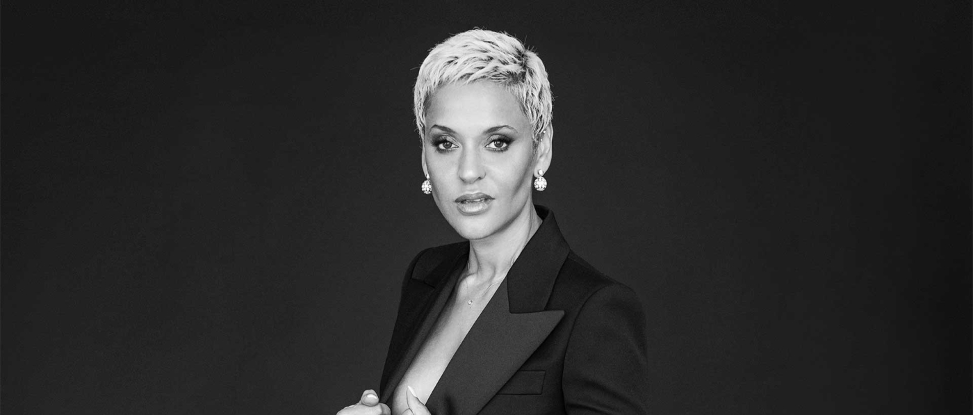 A black and white photo of Mariza in a suit seeming to sneer slightly at the camera