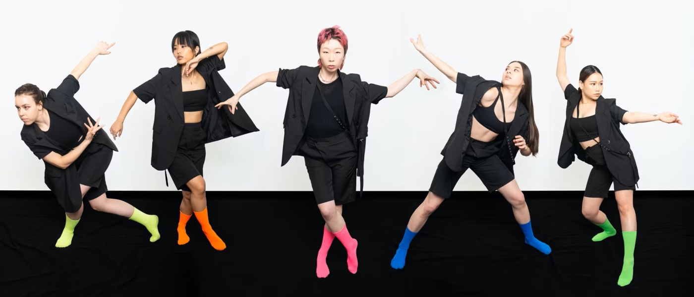 Five dancers from the Sun Kim Dance Theatre in black outfits and neon socks