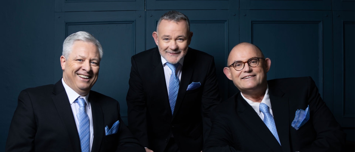 Anthony Kearns, Ronan Tynan and Declan Kelly, three older white men wearing black suits with blue ties