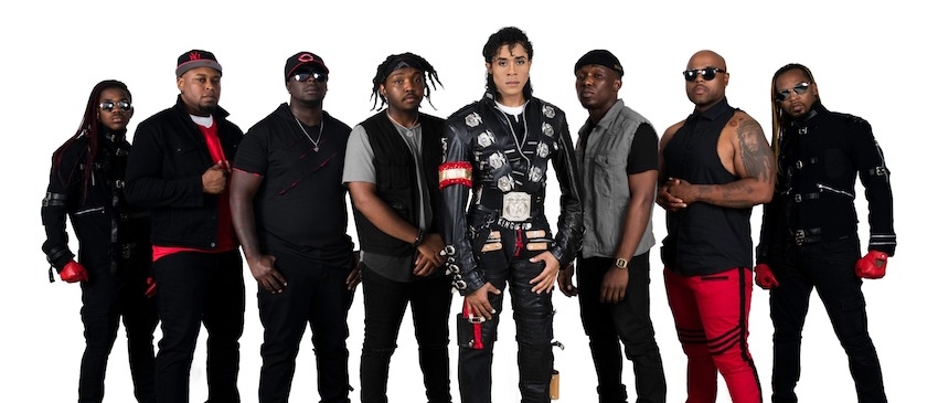 Nine Black men standing together, one of them dressed like Michael Jackson