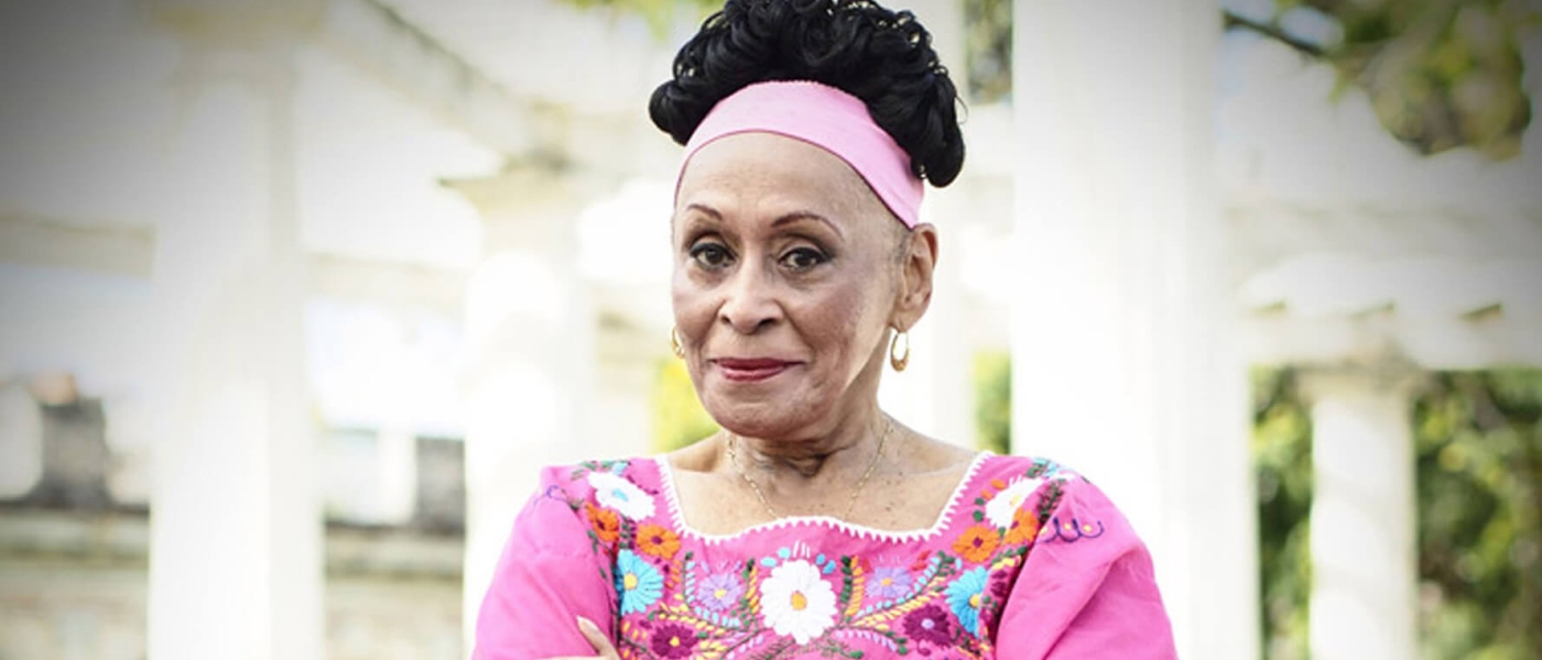 Omara Portuondo standing with her arms crossed