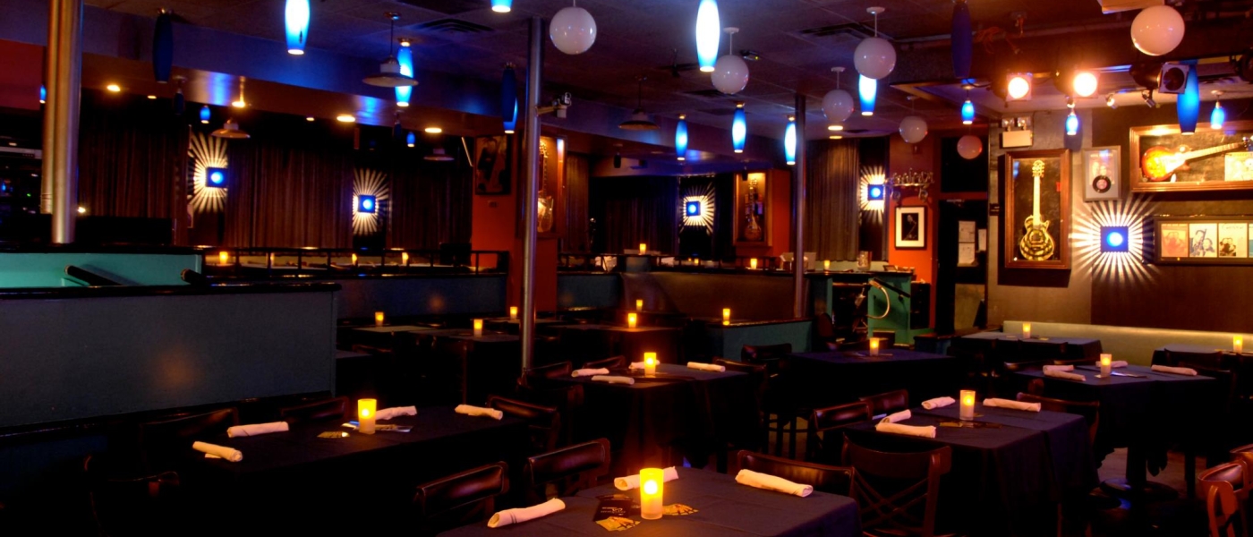 The interior of The Iridium, showing dining tables and wall decor including guitars