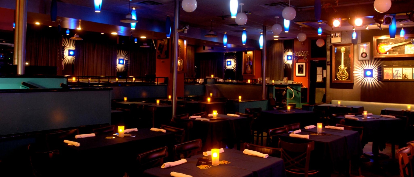 The interior of The Iridium, showing dining tables and wall decor including guitars