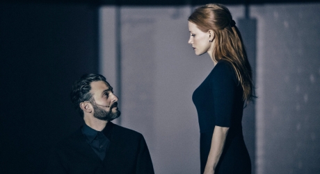 Arian Moayed, seated, and Jessica Chastain, standing and looking at him, in A Doll's House
