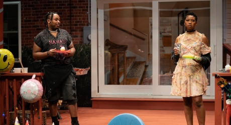 Marcel Spears as Juicy and Adrianna Mitchell as Opal in the Public Theater production of Fat Ham. Juicy wears black shorts and a shirt that says 
