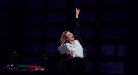 Jodie Comer in Prima Facie holding a box and thrusting her hand into the air triumphantly. Photo by Bronwen Sharp.